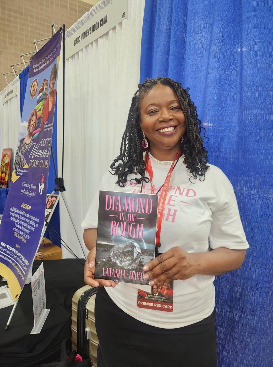 Latasha Davis holding her book Diamond in the Rough at a book club event